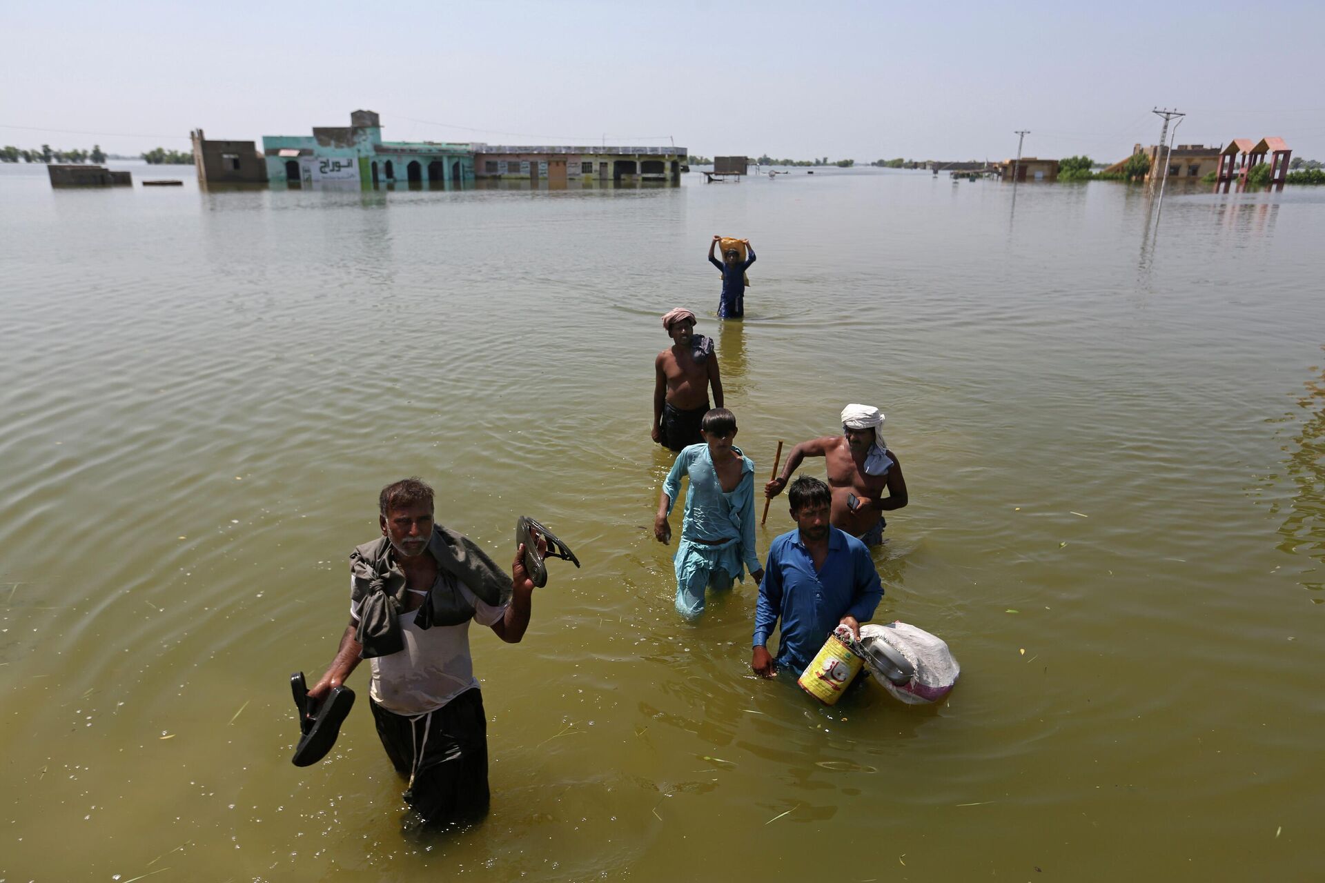 Victims of flooding from monsoon rains carry belongings salvaged from their flooded home in the Dadu district of Sindh Province, of Pakistan, Thursday, Sept. 8, 2022 - Sputnik International, 1920, 25.12.2022