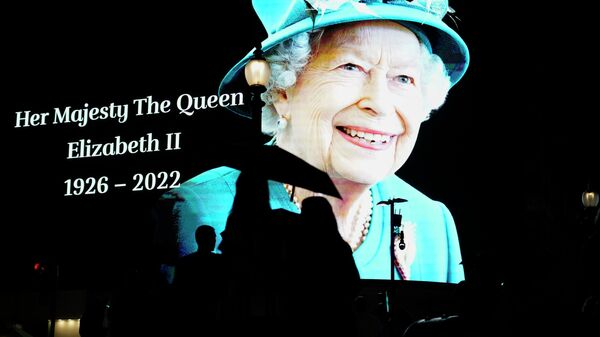 People pass by an image of Queen Elizabeth II projected onto a large screen at Piccadilly Circus, in London, Thursday, Sept. 8, 2022. - Sputnik International