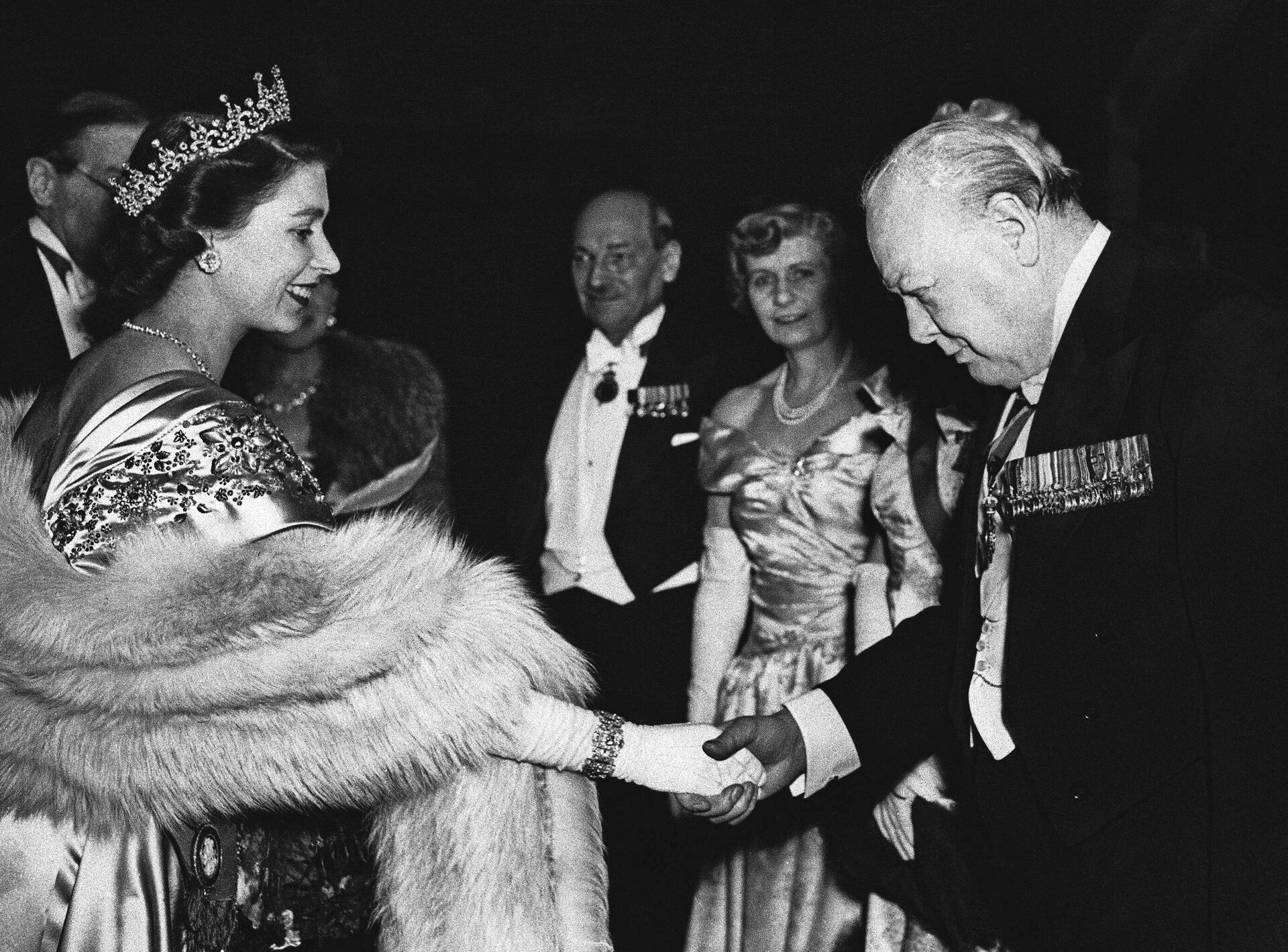 FILE - In this March 22, 1950 file photo, Britain's Princess Elizabeth shakes hands with Winston Churchill, former British Prime Minister, at a dinner to mark the launching of the Lord Mayor's National Thanksgiving Fund in London,. In background are Prime Minister Clement Attlee and his wife Violet. - Sputnik International, 1920, 09.09.2022