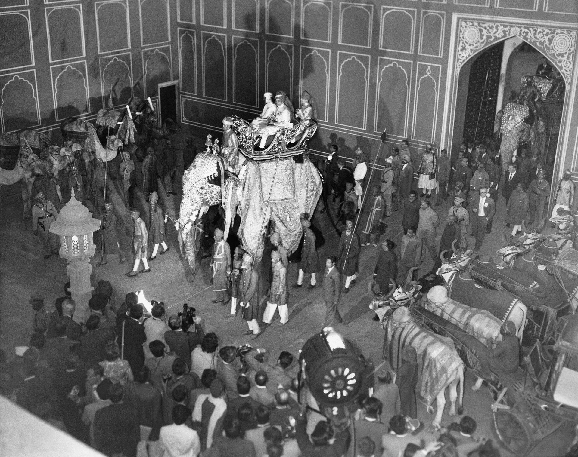 The scene of splendor as Queen Elizabeth II arrived on Jan. 22, 1961 at the palace in Jaipur, Rajasthan, Indian on the back of a huge, decorated elephant after the half-mile ride from the palace gates.   Riding in the golden howdah with her majesty is the Maharajah of Jaipur - Sputnik International, 1920, 09.09.2022