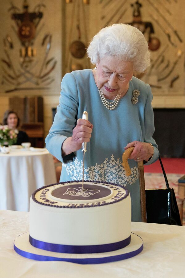 Королева Великобритании Елизавета II разрезает торт, чтобы отпраздновать начало семидесятой годовщины ее правления, 2022 год - Sputnik International