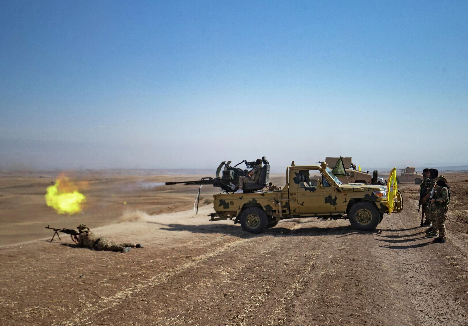 A fighter of the Syrian Democratic Forces (SDF) fires the turret of a technical vehicle during a joint exercise with forces of the US-led Combined Joint Task Force-Operation Inherent Resolve coalition against the Islamic State (IS) group in the countryside of the town of al-Malikiya (Derik in Kurdish) in Syria's northeastern Hasakah province on September 7, 2022 - Sputnik International, 1920, 09.09.2022