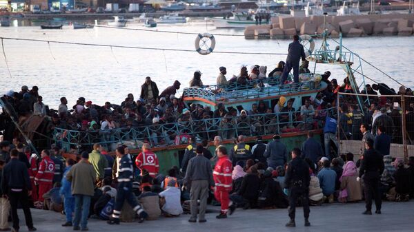 Immigrants disembark a boat at Lampedusa's harbor, Italy, Friday, April 8, 2011. After days of fierce sparring, Italy and France patched up their differences Friday over the fate of thousands of Tunisian migrants, avoiding a major rift over European Union border control rules. Top security officials from Italy and France sought a conciliatory tone as they struggled with the crush of more than 20,000 Tunisians who sailed on often rickety boats to Italy's southernmost point, the tiny Mediterranean island of Lampedusa. (AP Photo/Giorgos Moutafis)  GREECE OUT - Sputnik International
