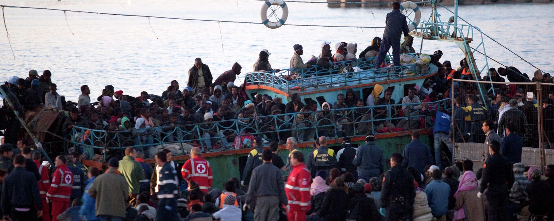 Immigrants disembark a boat at Lampedusa's harbor, Italy, Friday, April 8, 2011. After days of fierce sparring, Italy and France patched up their differences Friday over the fate of thousands of Tunisian migrants, avoiding a major rift over European Union border control rules. Top security officials from Italy and France sought a conciliatory tone as they struggled with the crush of more than 20,000 Tunisians who sailed on often rickety boats to Italy's southernmost point, the tiny Mediterranean island of Lampedusa. (AP Photo/Giorgos Moutafis)  GREECE OUT - Sputnik International, 1920, 28.03.2023