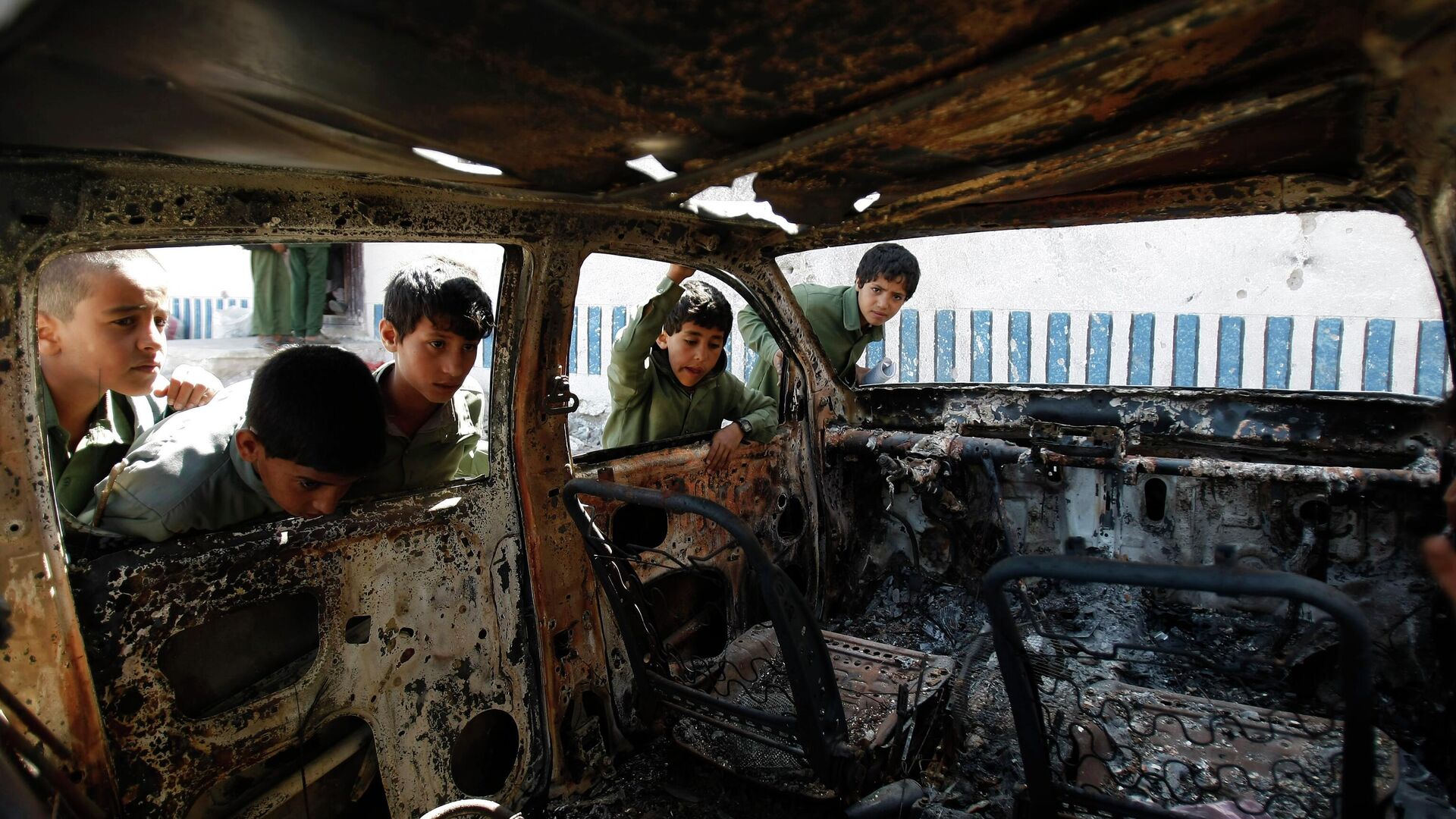 FILE – This May 27, 2014, file photo shows Yemeni boys looking at a vehicle destroyed during a police raid on an al-Qaida militants' hideout in the Arhab region, north of Sanaa, Yemen, which resulted in the death of five militants and six soldiers. According to the Obama administration’s most recent terrorism report, released by the State Department in late April, al-Qaida's core leadership has been degraded, limiting its ability to launch attacks and lead its followers. This has resulted in more autonomous and more aggressive affiliates, notably in Yemen, Syria, Iraq, northwest Africa and Somalia, according to the report, which recorded a 43 percent increase in terrorist attacks worldwide from 2012 to 2013. (AP Photo/Hani Mohammed) - Sputnik International, 1920, 01.04.2023