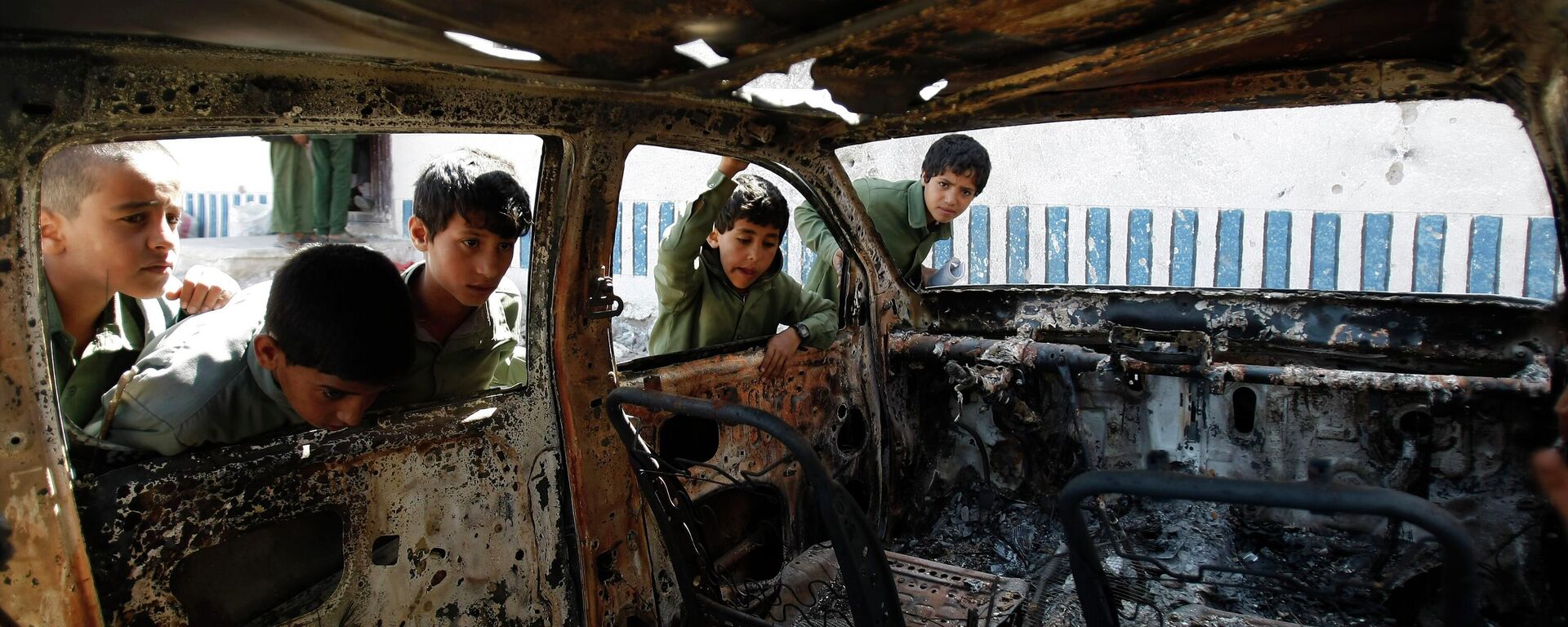 FILE – This May 27, 2014, file photo shows Yemeni boys looking at a vehicle destroyed during a police raid on an al-Qaida militants' hideout in the Arhab region, north of Sanaa, Yemen, which resulted in the death of five militants and six soldiers. According to the Obama administration’s most recent terrorism report, released by the State Department in late April, al-Qaida's core leadership has been degraded, limiting its ability to launch attacks and lead its followers. This has resulted in more autonomous and more aggressive affiliates, notably in Yemen, Syria, Iraq, northwest Africa and Somalia, according to the report, which recorded a 43 percent increase in terrorist attacks worldwide from 2012 to 2013. (AP Photo/Hani Mohammed) - Sputnik International, 1920, 01.04.2023