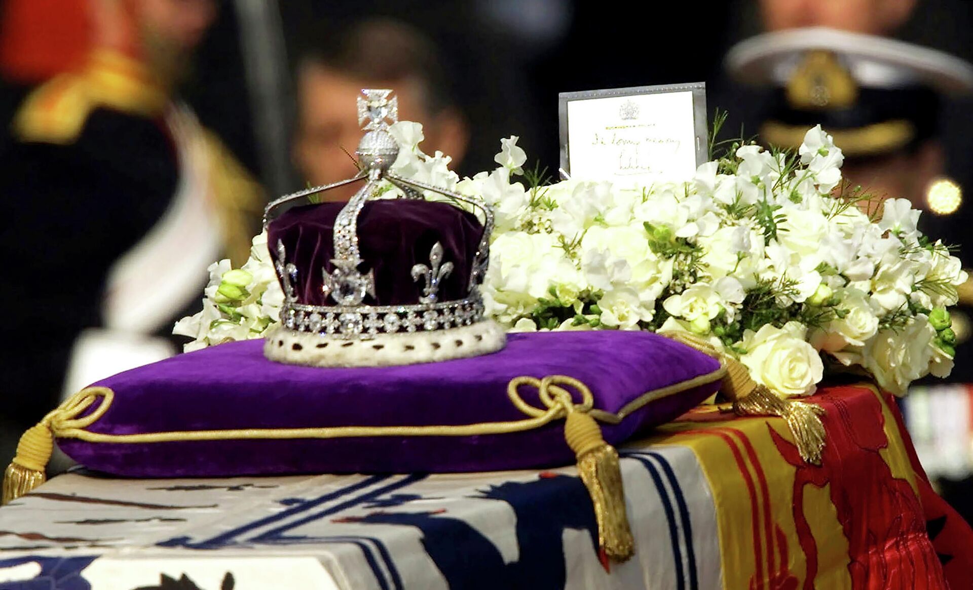 The Koh-i-noor, or mountain of light, diamond, set in the Maltese Cross at the front of the crown made for Britain's late Queen Mother Elizabeth, is seen on her coffin, along with her personal standard, a wreath and a note from her daughter, Queen Elizabeth II, as it is drawn to London's Westminster Hall, April 5, 2002. - Sputnik International, 1920, 13.09.2022