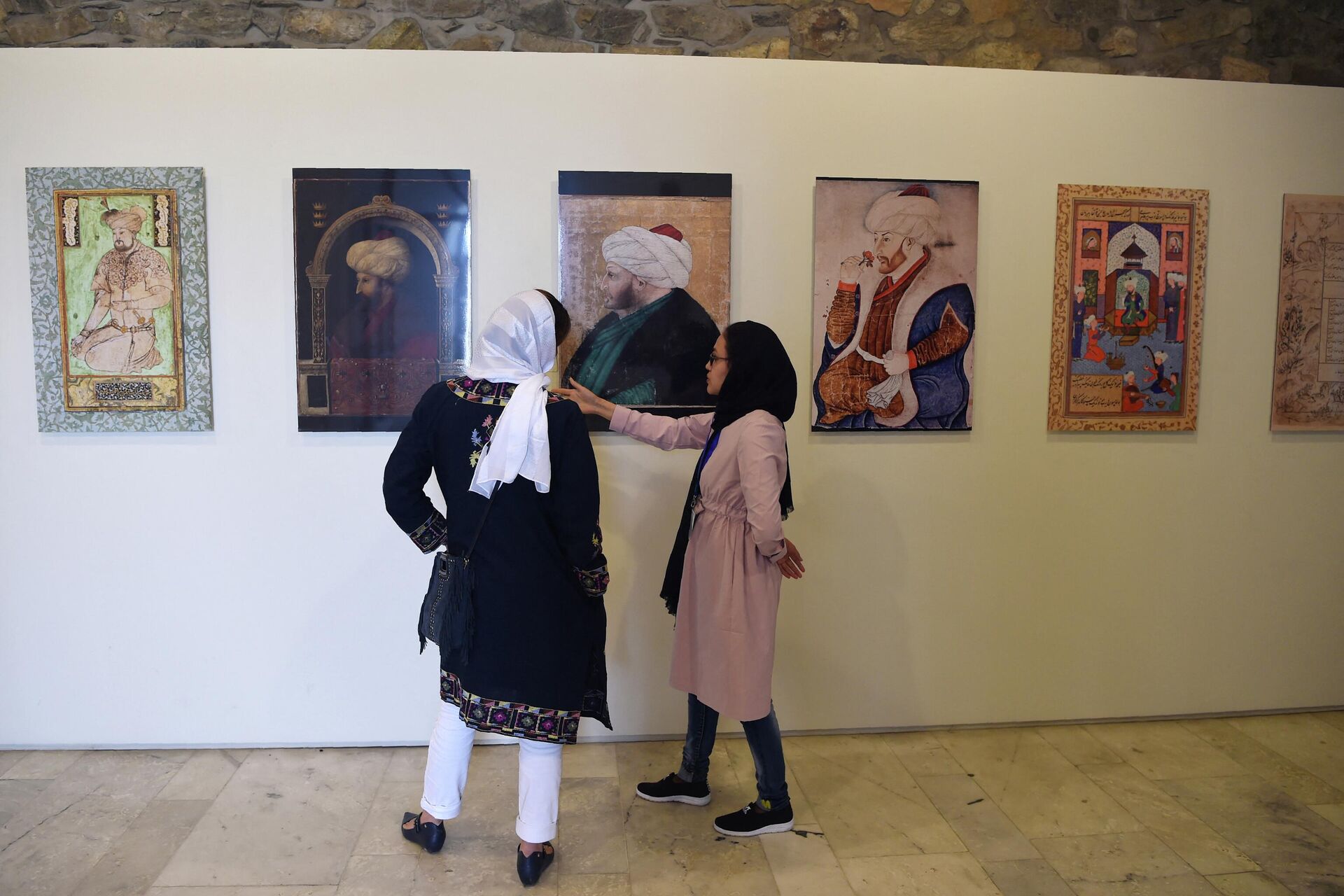In this photograph taken on April 15, 2018, Afghan visitors walk past a display of Mughal paintings at the 'King Babur's Kabul, Cradle of the Mughal Empire' exhibition at the Bagh-e-Babur Garden in Kabul. - Sputnik International, 1920, 13.09.2022