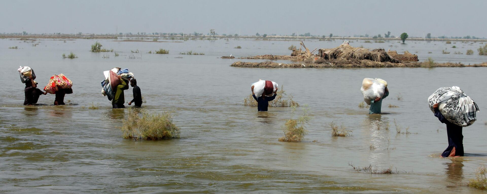 FILE - Victims of heavy flooding from monsoon rains crowd carry relief aid through flood water in the Qambar Shahdadkot district of Sindh Province, Pakistan, Sept. 9, 2022 - Sputnik International, 1920, 14.09.2022