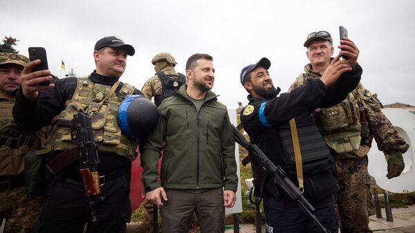 Ukrainian President Volodymyr Zelensky poses with soldiers, including a trooper wearing an SS-Totenkopf badge, during a visit to Kharkov region. - Sputnik International