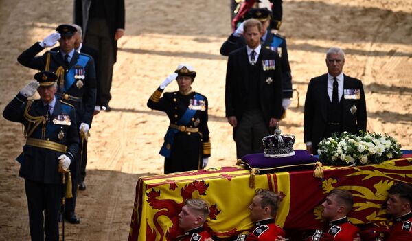 Britain&#x27;s King Charles III, Britain&#x27;s Prince William, Prince of Wales and Britain&#x27;s Princess Anne, Princess Royal salute, alongside Britain&#x27;s Prince William, Prince of Wales and Britain&#x27;s Prince Andrew, Duke of York as the coffin of Queen Elizabeth II, adorned with a Royal Standard and the Imperial State Crown, arrives at the Palace of Westminster, following a procession from Buckingham Palace, in London on September 14, 2022. - Queen Elizabeth II will lie in state in Westminster Hall inside the Palace of Westminster, from Wednesday until a few hours before her funeral on Monday, with huge queues expected to file past her coffin to pay their respects. - Sputnik International