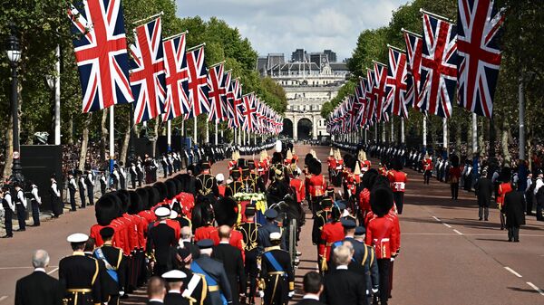 The coffin of Queen Elizabeth II, adorned with a Royal Standard and the Imperial State Crown is pulled by a Gun Carriage of The King's Troop Royal Horse Artillery, during a procession from Buckingham Palace to the Palace of Westminster, in London on September 14, 2022. - Sputnik International