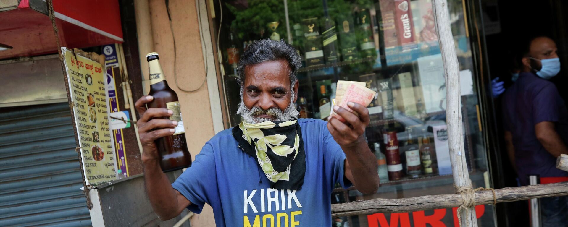 An Indian man reacts in joy after buying a bottle of liquor from an outlet during a lockdown to curb the spread of new coronavirus, in Bangalore, India, Wednesday, May 6, 2020 - Sputnik International, 1920, 16.09.2022