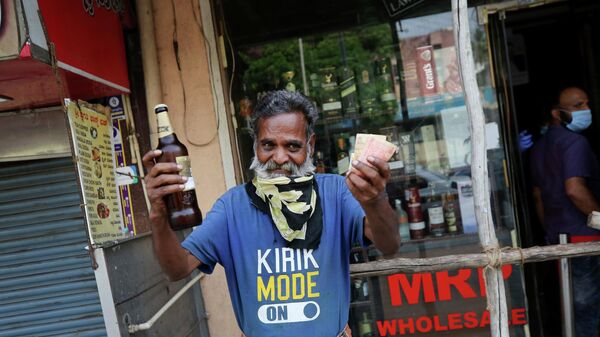 An Indian man reacts in joy after buying a bottle of liquor from an outlet during a lockdown to curb the spread of new coronavirus, in Bangalore, India, Wednesday, May 6, 2020 - Sputnik International