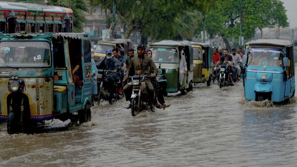 Motorists make their way through a flooded street after heavy rains in Karachi on September 12, 2022. - Sputnik International