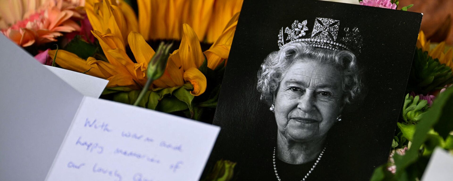 A portrait of late Queen Elizabeth II is pictured among flowers and tributes left in Green Park in London on September 18, 2022, following her death on September 8 - Sputnik International, 1920, 18.09.2022