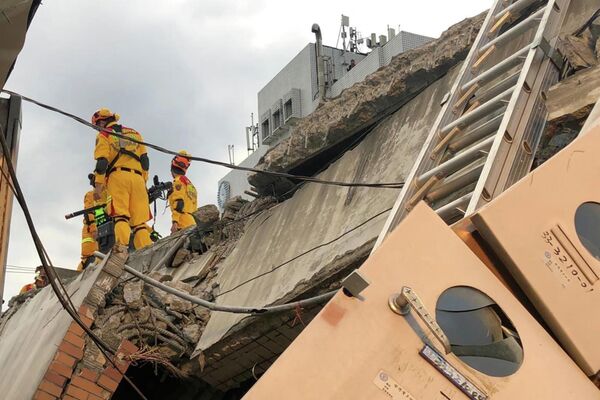 Пожарные на разрушенном здании в результате землетрясения на Тайване  - Sputnik International