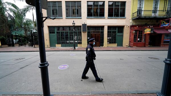A police officer walks down a nearly deserted Bourbon Street during Mardi Gras in the French Quarter of New Orleans, Tuesday, Feb. 16, 2021. - Sputnik International