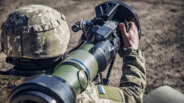 This handout picture taken and released on February 19, 2022 by the press service of the General Staff of the Ukrainian Armed Forces in an unknown location in Ukraine, shows a soldier examining a Swedish-British portable anti-tank guided missile NLAW that was transferred to the units as part of Britain's military-technical assistance - Sputnik International