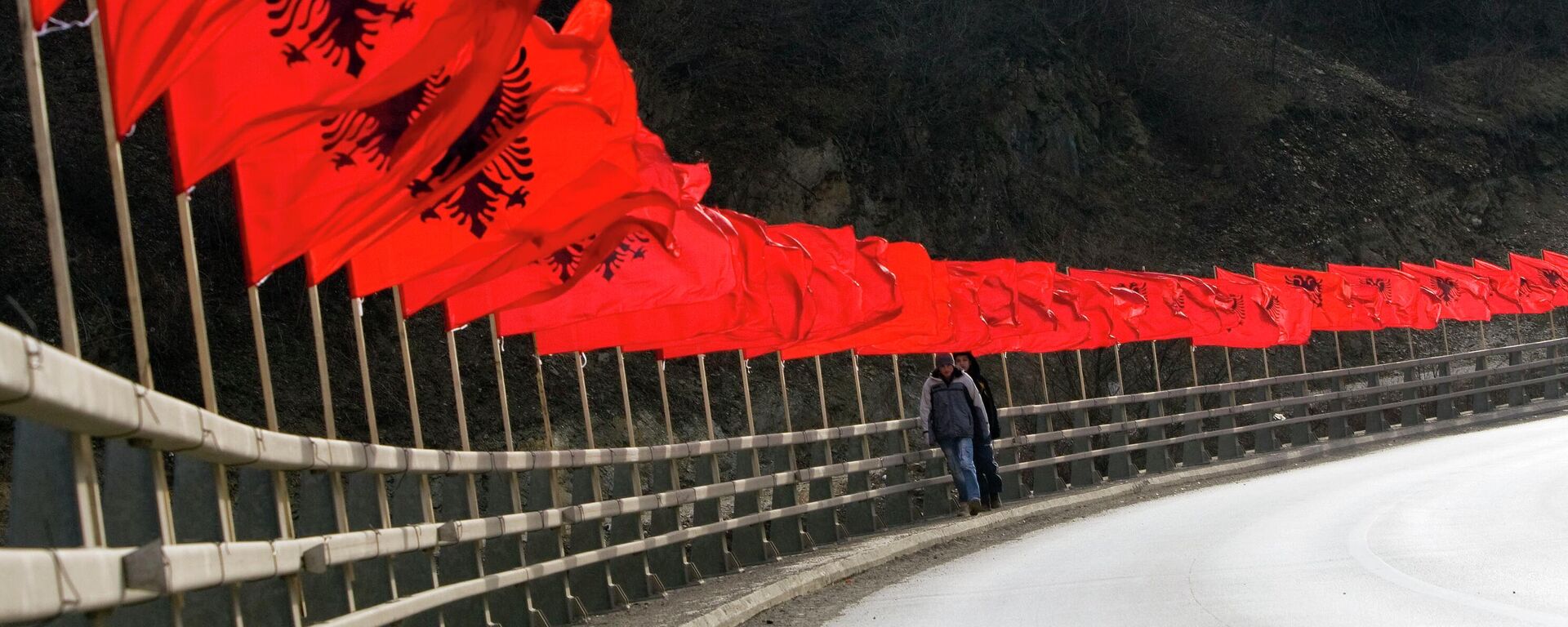 Kosovans cross a bridge decorated with dozen of Albanian national flags a year after the majority Albanian territory defiantly declared independence from Serbia in the town of Kacanik, Kosovo on Monday, Feb. 16, 2009 - Sputnik International, 1920, 15.12.2022