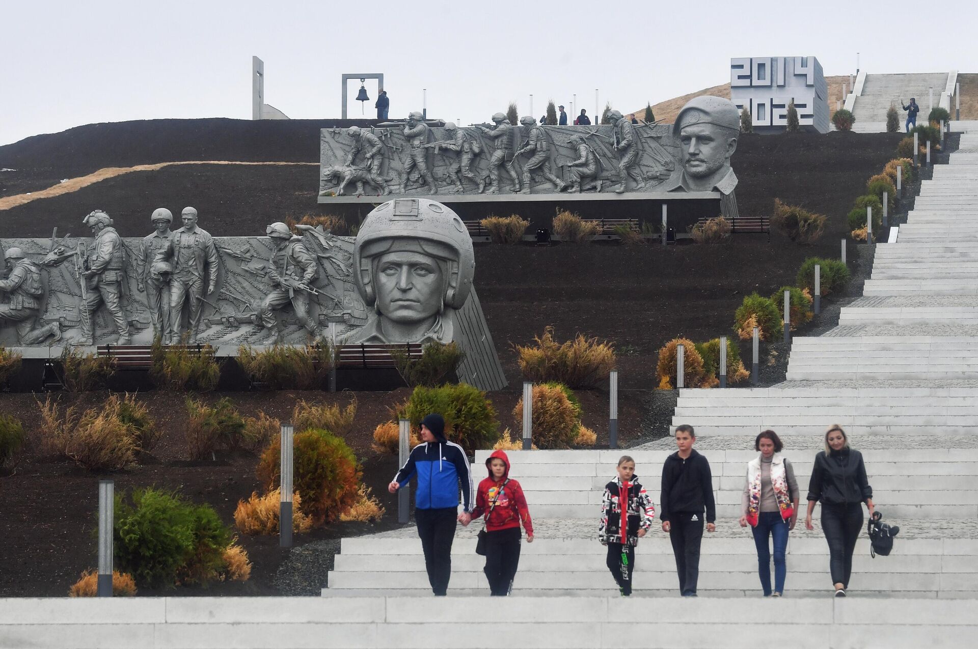 People walk down the stairs at the Savur-Mogyla war memorial complex with a bas-relief of Vladimir Zhoga, leader of the Sparta Battalion rebel military group in the Donetsk People's Republic (DPR), seen in the background, as Russia's military operation in Ukraine continues, near the city of  Snezhnoe, Donetsk People's Republic - Sputnik International, 1920, 31.12.2022