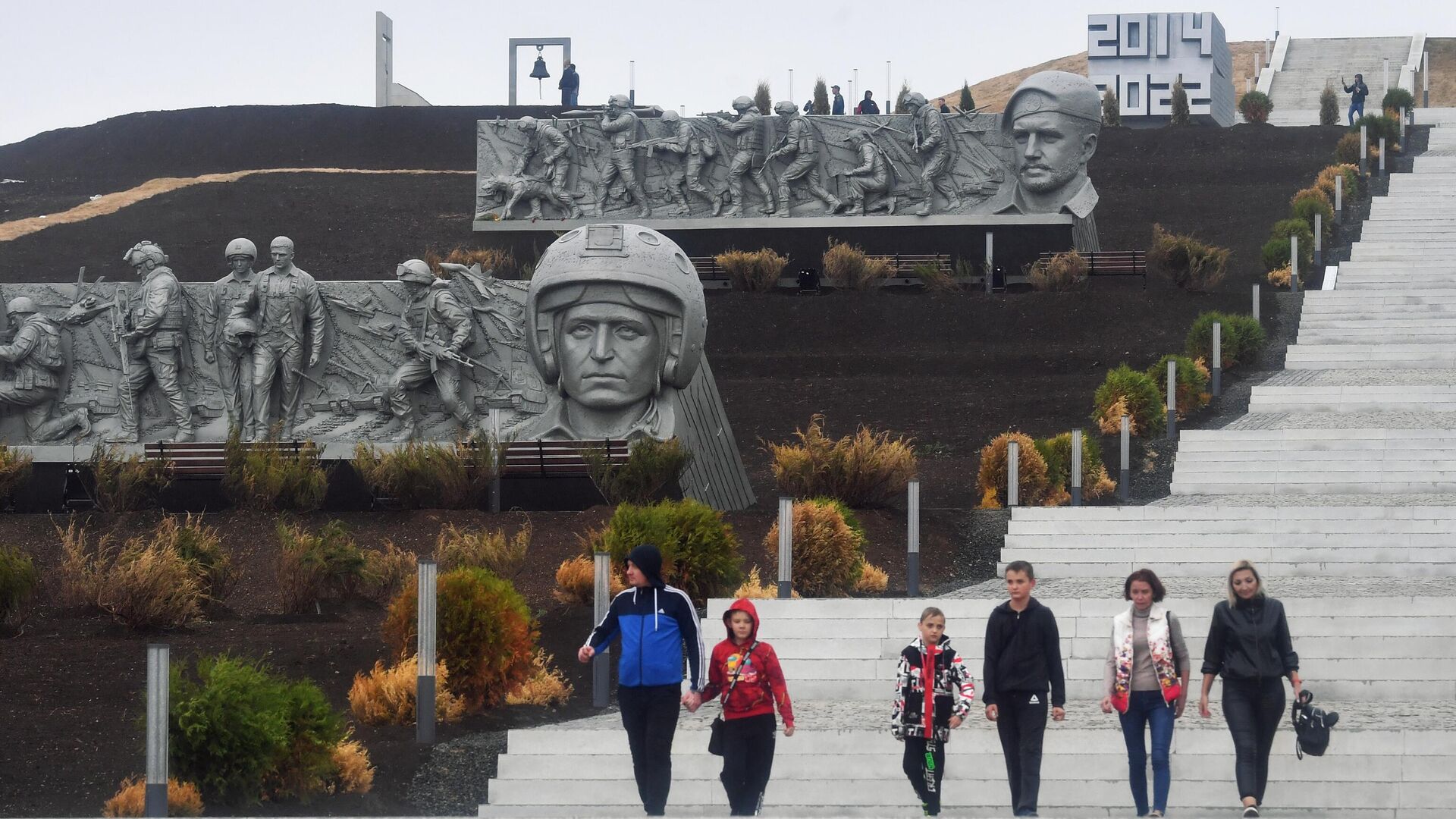 People walk down the stairs at the Savur-Mogyla war memorial complex with a bas-relief of Vladimir Zhoga, leader of the Sparta Battalion rebel military group in the Donetsk People's Republic (DPR), seen in the background, as Russia's military operation in Ukraine continues, near the city of  Snezhnoe, Donetsk People's Republic - Sputnik International, 1920, 20.09.2022