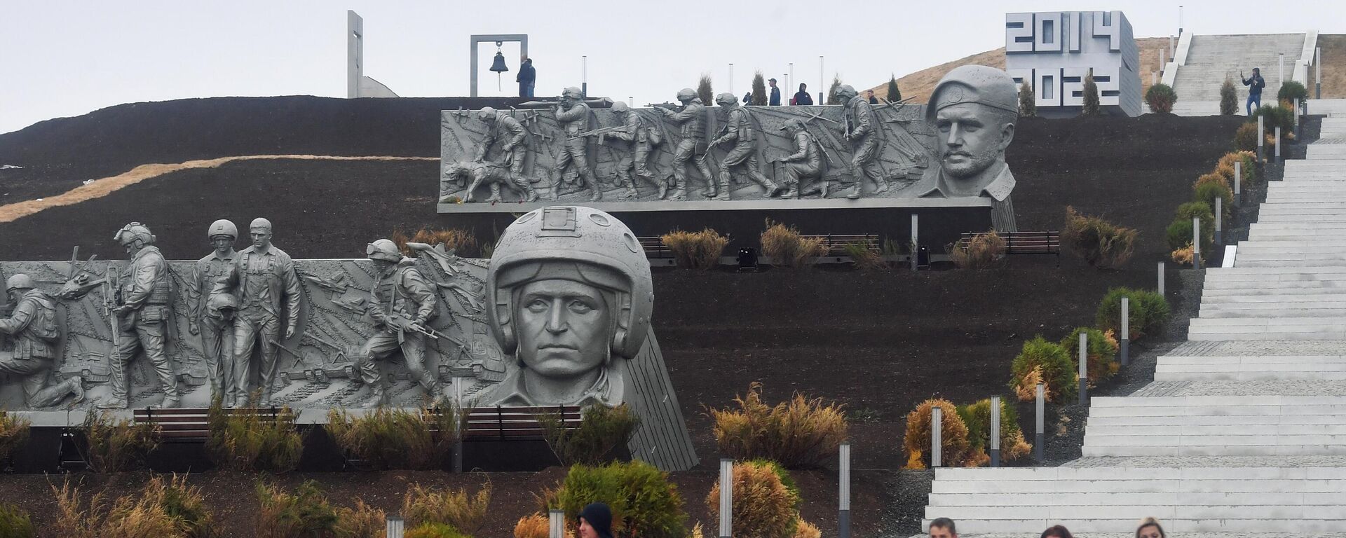 People walk down the stairs at the Savur-Mogyla war memorial complex with a bas-relief of Vladimir Zhoga, leader of the Sparta Battalion rebel military group in the Donetsk People's Republic (DPR), seen in the background, as Russia's military operation in Ukraine continues, near the city of  Snezhnoe, Donetsk People's Republic - Sputnik International, 1920, 20.09.2022