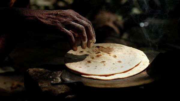An Indian woman cooks chapati, or Indian bread, on a roadside in Allahabad, India, Friday, July 5, 2013.  - Sputnik International