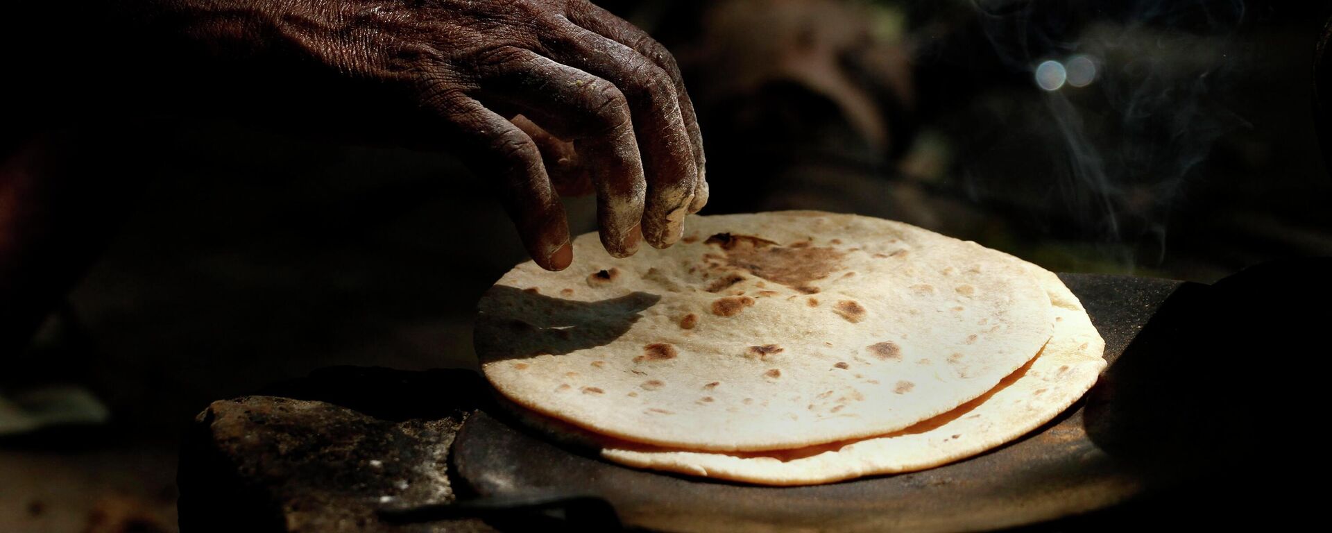 An Indian woman cooks chapati, or Indian bread, on a roadside in Allahabad, India, Friday, July 5, 2013.  - Sputnik International, 1920, 20.09.2022
