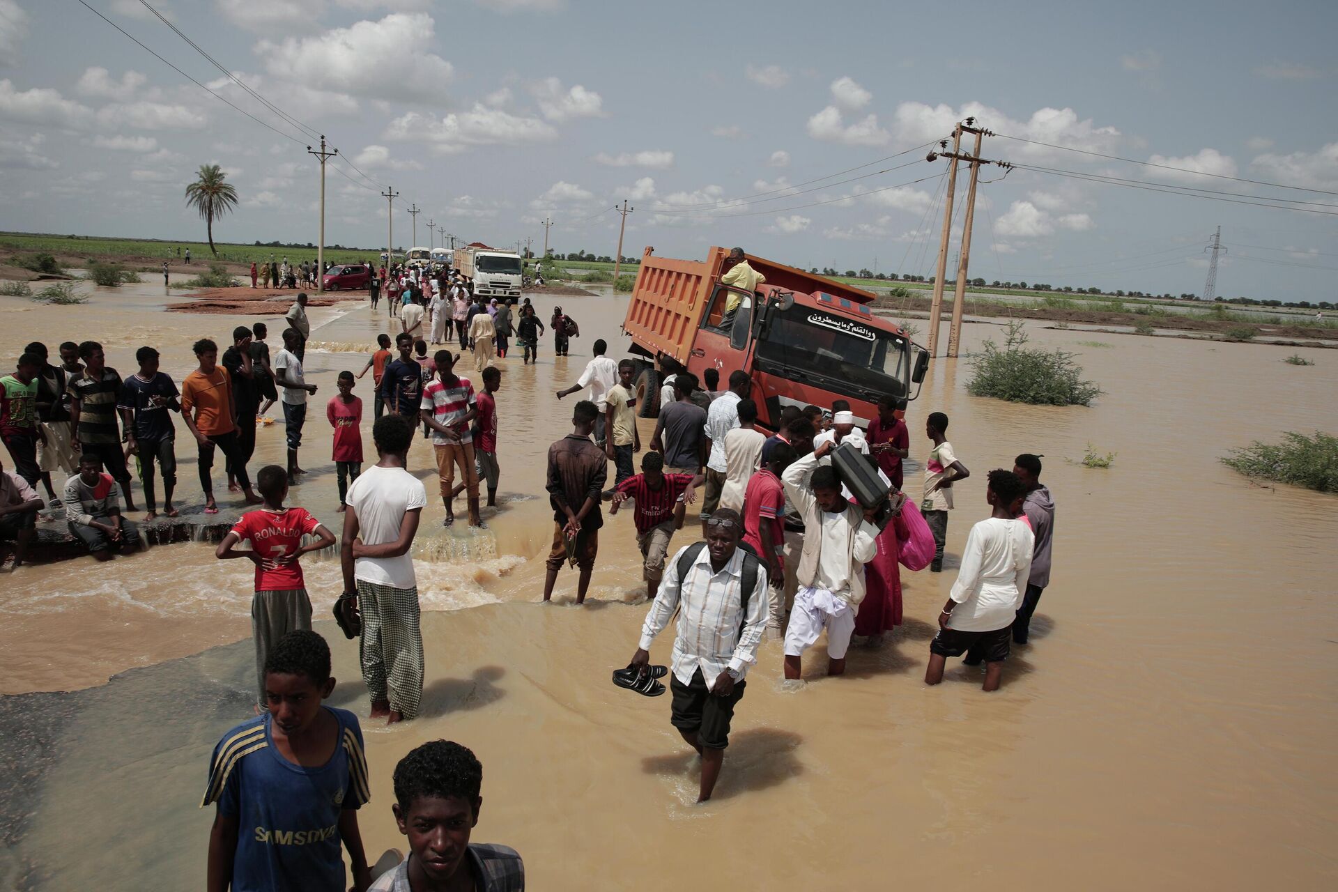 People walk on a flooded road after a heavy rainfall in the village of Aboud in the El-Manaqil district of the Al-Jazirah province, southeast of Khartoum, Sudan, Monday, August 22 2022. - Sputnik International, 1920, 20.09.2022