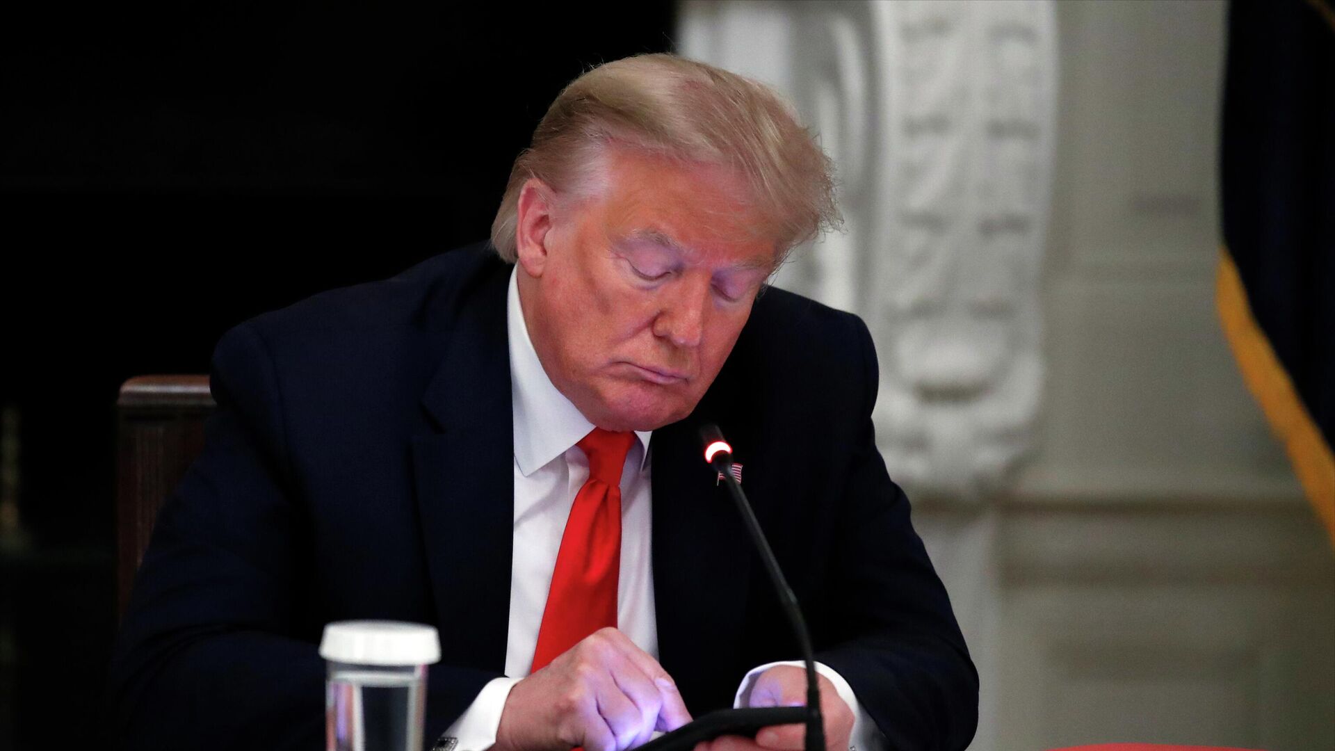 President Donald Trump looks at his phone during a roundtable with governors on the reopening of America's small businesses, in the State Dining Room of the White House in Washington, June 18, 2020 - Sputnik International, 1920, 05.04.2023