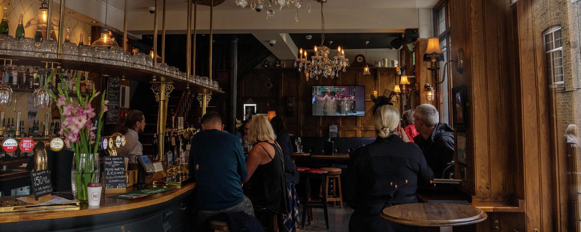 People watch live news in a pub showing the funeral service of Queen Elizabeth II at a London pub - Sputnik International, 1920, 21.09.2022