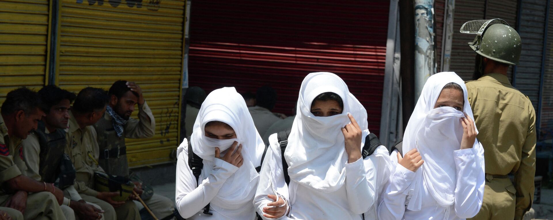 Kashmiri schoolgirls walk past Indian policemen as they conduct a patrol in Srinagar - Sputnik International, 1920, 22.09.2022
