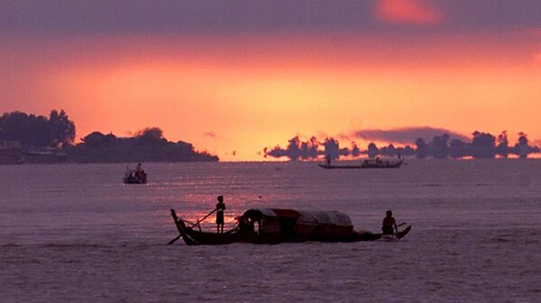 Dawn breaks over the Mekong River as small fishing boats drift downstream casting their nets in Phnom Penh, Cambodia, Oct. 29, 2002 - Sputnik International