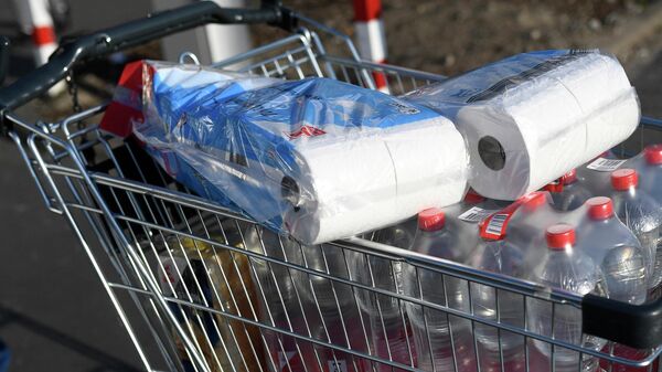 A picture taken on photo on March 16, 2020 shows a shopping cart with toilet paper and mineral water at a supermarket in Dortmund - Sputnik International