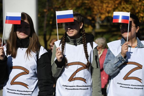 Women seen holding Russian flags during a rally in Central Park, Novosibirsk in support of Russian President Vladimir Putin and referendums in Donbass, and the Kherson and Zaporozhye regions on joining Russia. - Sputnik International