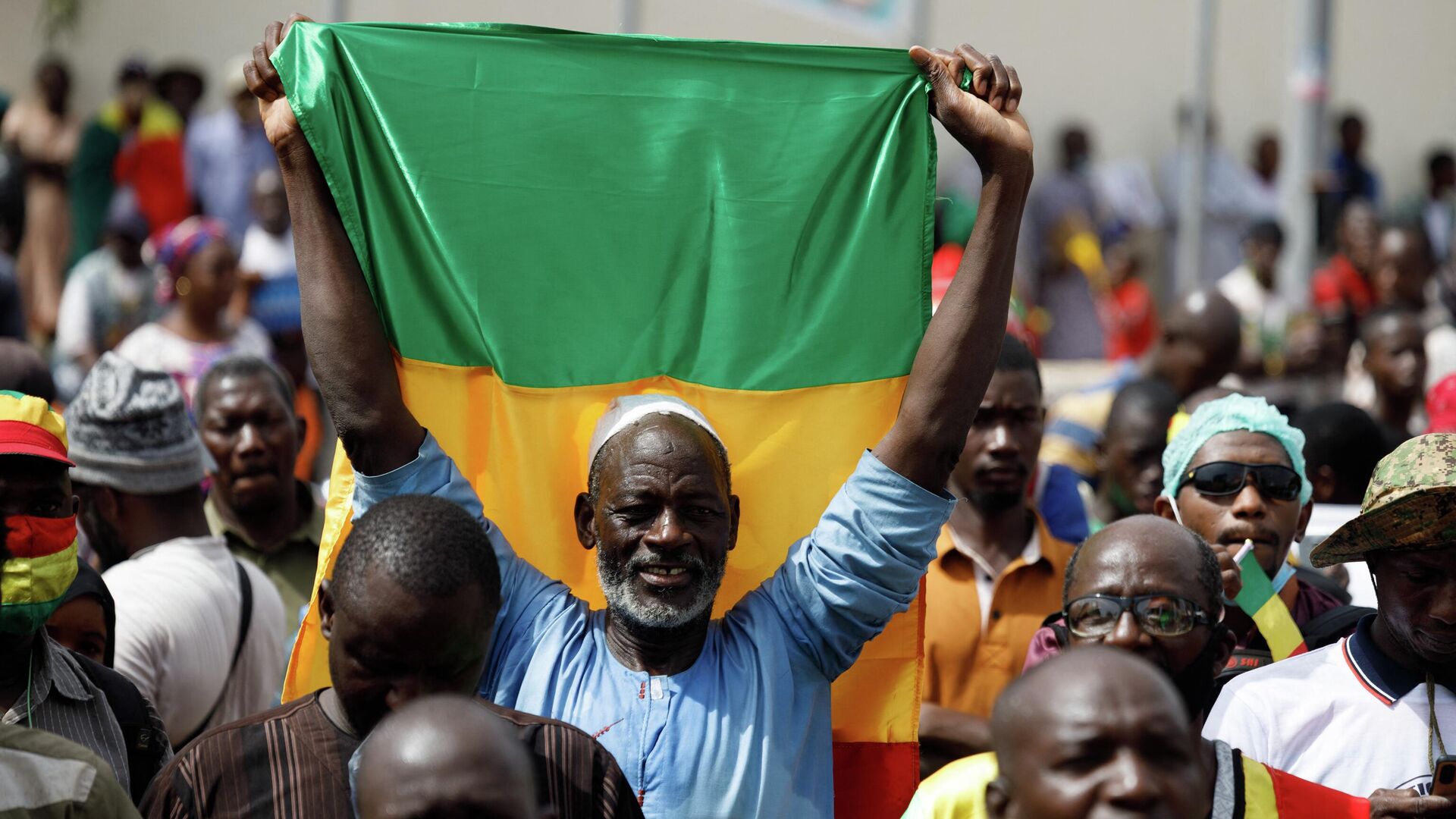 A supporter of Malian Interim President holds up the flag of Mali during a pro-Junta and pro-Russia rally in Bamako on May 13, 2022. - Several hundred Malians have gathered in Bamako to support the junta, the army and military cooperation with the Russians, AFP journalists report. (Photo by OUSMANE MAKAVELI / AFP) - Sputnik International, 1920, 24.09.2022