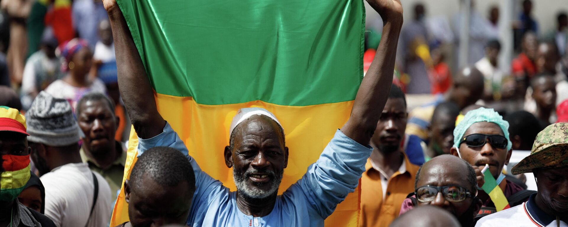 A supporter of Malian Interim President holds up the flag of Mali during a pro-Junta and pro-Russia rally in Bamako on May 13, 2022. - Several hundred Malians have gathered in Bamako to support the junta, the army and military cooperation with the Russians, AFP journalists report. (Photo by OUSMANE MAKAVELI / AFP) - Sputnik International, 1920, 24.09.2022