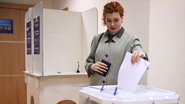 A woman prepares to put her ballot into a ballot box during the referendum on the joining of Donetsk and Lugansk People's Republic to Russia - Sputnik International