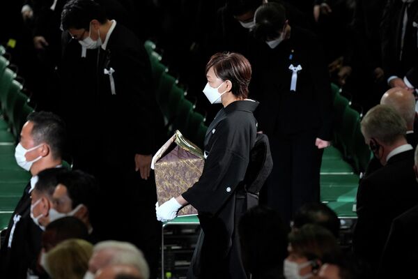 Жена экс-премьера Японии Синдзо Абэ с урной с его прахом на государственных похоронах в Токио  - Sputnik International