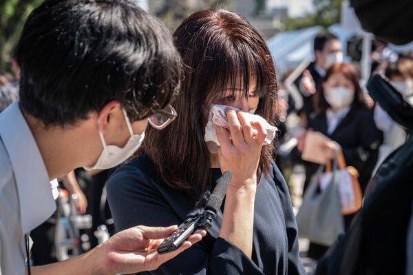 A woman cries during an interview after flower offering in a park near the Nippon Budokan ahead of the state funeral for former Japanese prime minister Shinzo Abe in Tokyo on September 27, 2022.  - Sputnik International