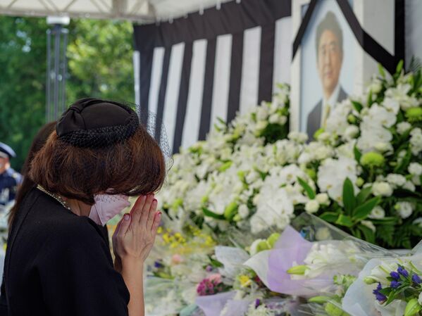 Женщина у портрета экс-премьера Японии Синдзо Абэ до начала государственных похорон в Токио  - Sputnik International