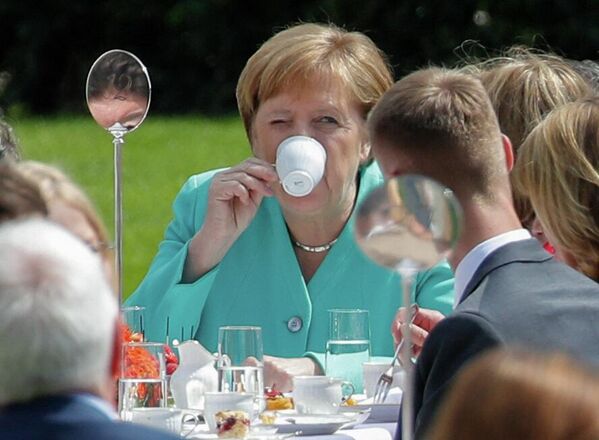 German Chancellor Angela Merkel drinks coffee as she attends a &quot;coffee table&quot; event hosted by the German President to celebrate the 70th anniversary of the Constitution (Grundgesetz) in the garden of the presidential residence Bellevue Palace in Berlin on 23 May 2019. - Sputnik International