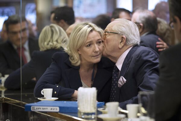 French right-wing FN party president Marine Le Pen (L) kisses her father Jean-Marie Le Pen in a cafe after registering her lists for the European elections at the Ministry of the Interior in Paris, on 25 April 2014. - Sputnik International