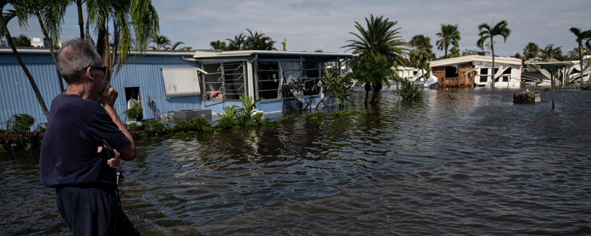 A man looks on from the a flooded street of a neighborhood in Fort Myers, Florida on September 29, 2022. - Hurricane Ian left much of coastal southwest Florida in darkness early on Thursday, bringing catastrophic flooding that left officials readying a huge emergency response to a storm of rare intensity. - Sputnik International, 1920, 03.10.2022
