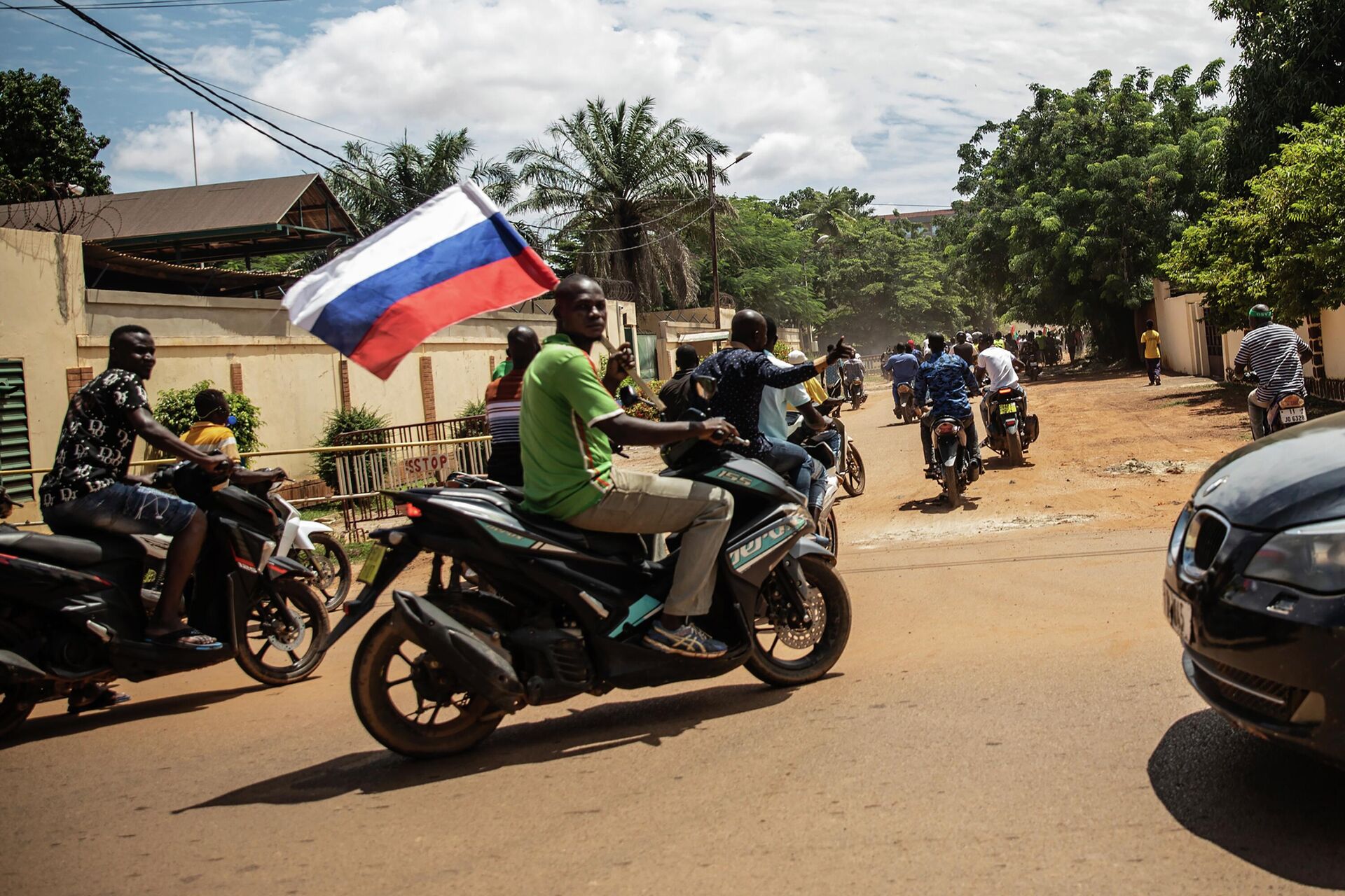Supporters of Capt. Ibrahim Traore parade waving a Russian flag in the streets of Ouagadougou, Burkina Faso, Sunday, Oct. 2, 2022. Burkina Faso's new junta leadership is calling for calm after the French Embassy and other buildings were attacked. The unrest following the West African nation's second coup this year came after a junta statement alleged that the ousted interim president was at a French military base in Ouagadougou. France vehemently denied the claim and has urged its citizens to stay indoors amid rising anti-French sentiment in the streets. (AP Photo/Sophie Garcia) - Sputnik International, 1920, 15.10.2022