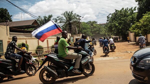 Supporters of Capt. Ibrahim Traore parade waving a Russian flag in the streets of Ouagadougou, Burkina Faso, Sunday, Oct. 2, 2022. Burkina Faso's new junta leadership is calling for calm after the French Embassy and other buildings were attacked. The unrest following the West African nation's second coup this year came after a junta statement alleged that the ousted interim president was at a French military base in Ouagadougou. France vehemently denied the claim and has urged its citizens to stay indoors amid rising anti-French sentiment in the streets. (AP Photo/Sophie Garcia) - Sputnik International