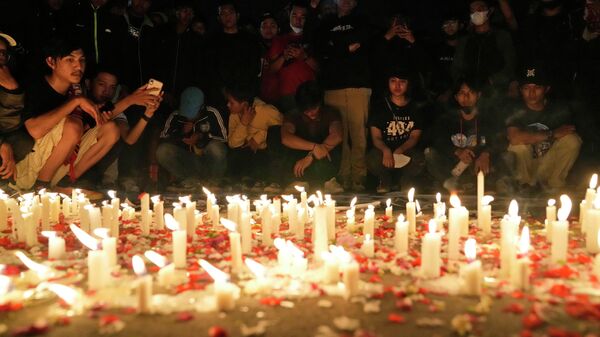 Indonesian soccer fans light candles during a vigil for the victims of Saturday's soccer riots, in Jakarta, Indonesia - Sputnik International