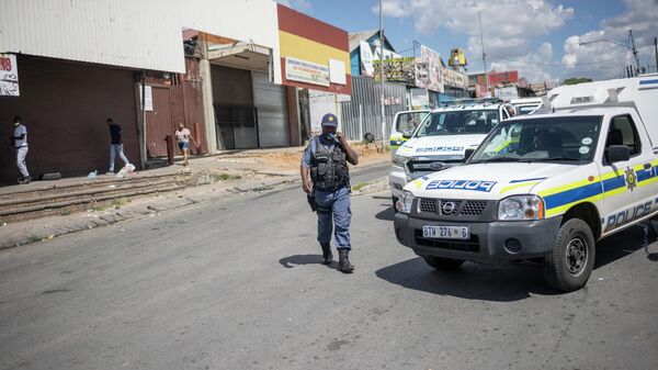 A member of the South African Police Service (SAPS) walks toward his vehicle - Sputnik International