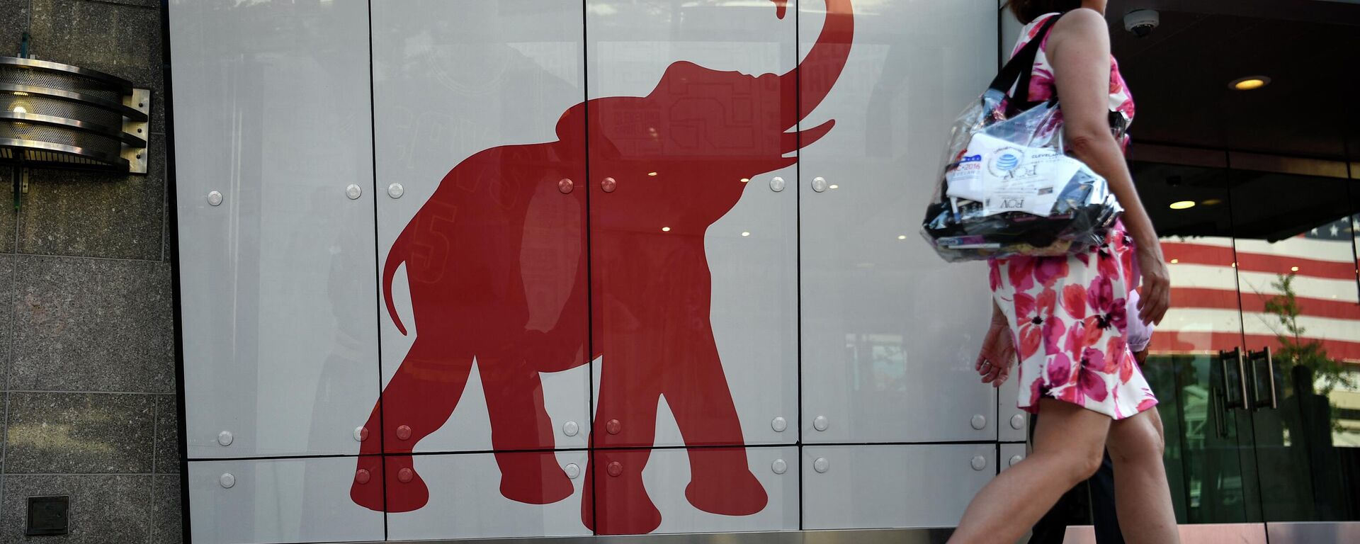 A woman walks past the elephant logo of the Republican Party on the first day of the  Republican National Convention on July 18, 2016 in Cleveland, Ohio - Sputnik International, 1920, 03.10.2022